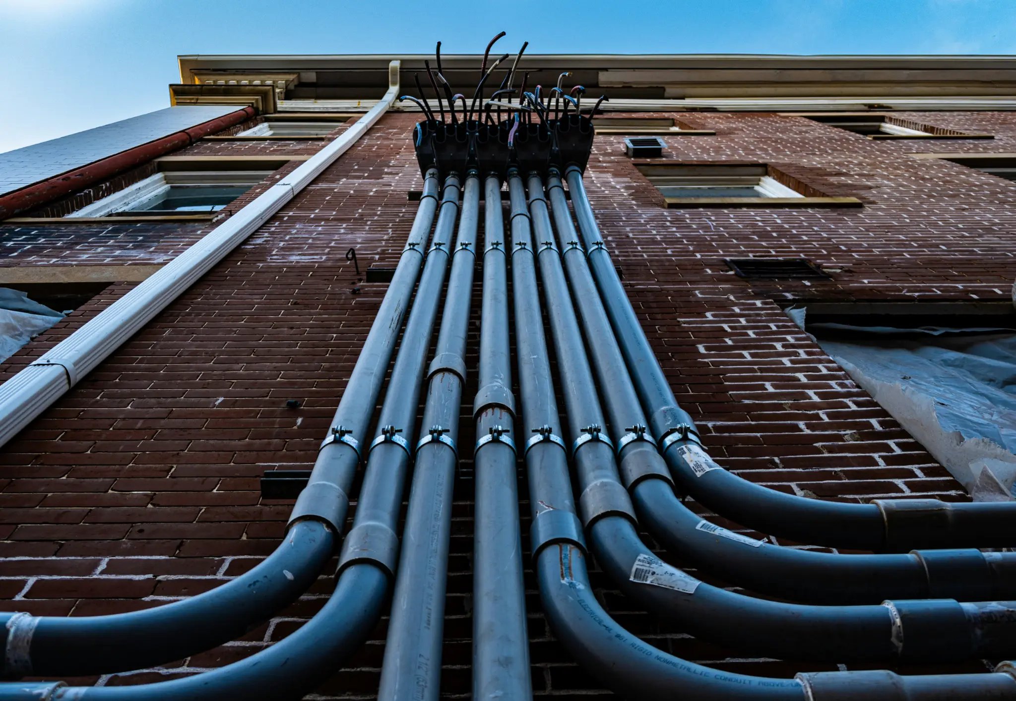 Electrical conduit on a brick building — trade work in the field